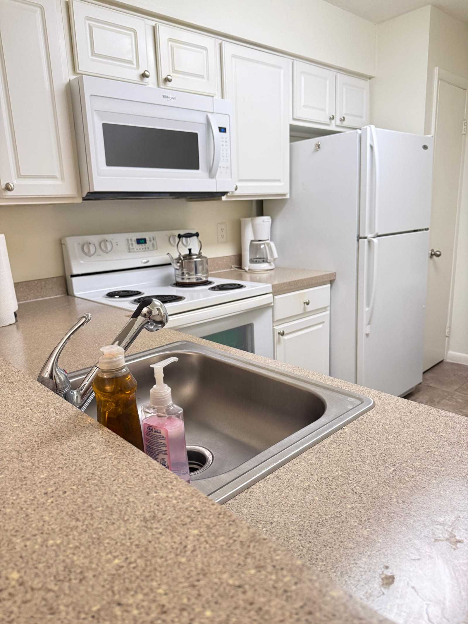 The kitchen counter and sink, looking across to the cooker and the refrigerator beyond.