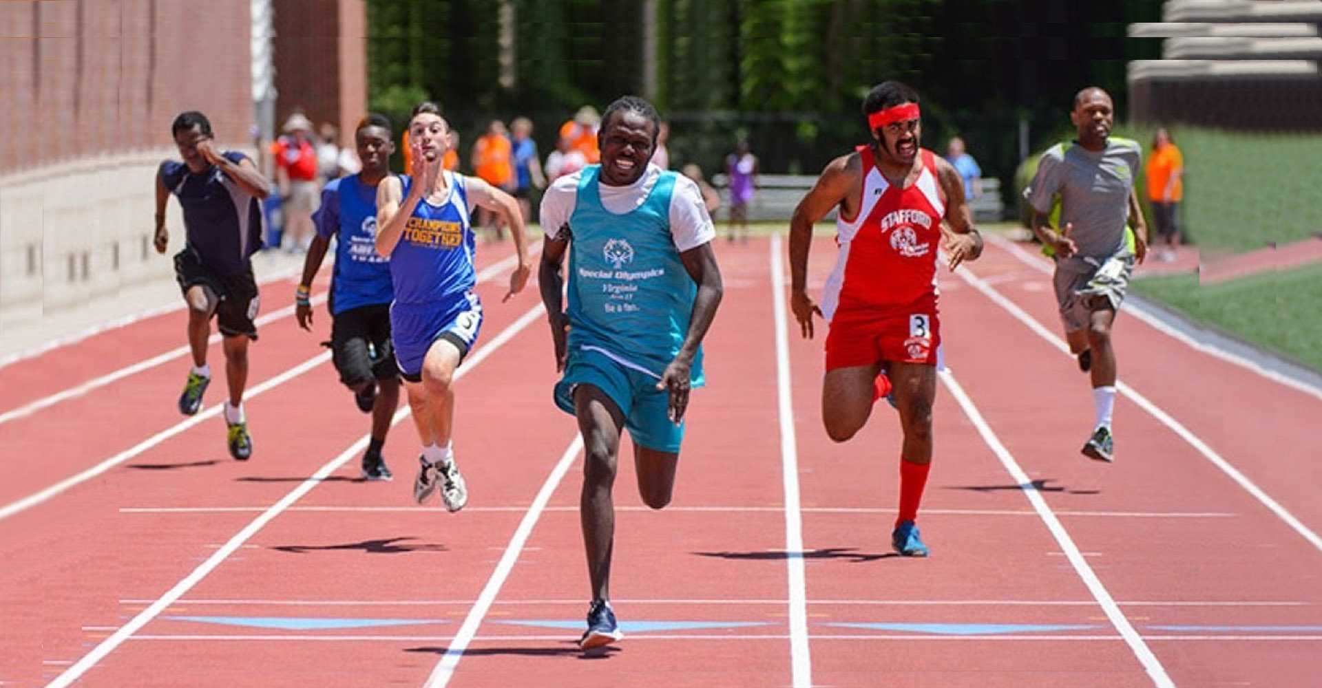 Athletes competing in a Special Olympics sprint race on an outdoor running track.